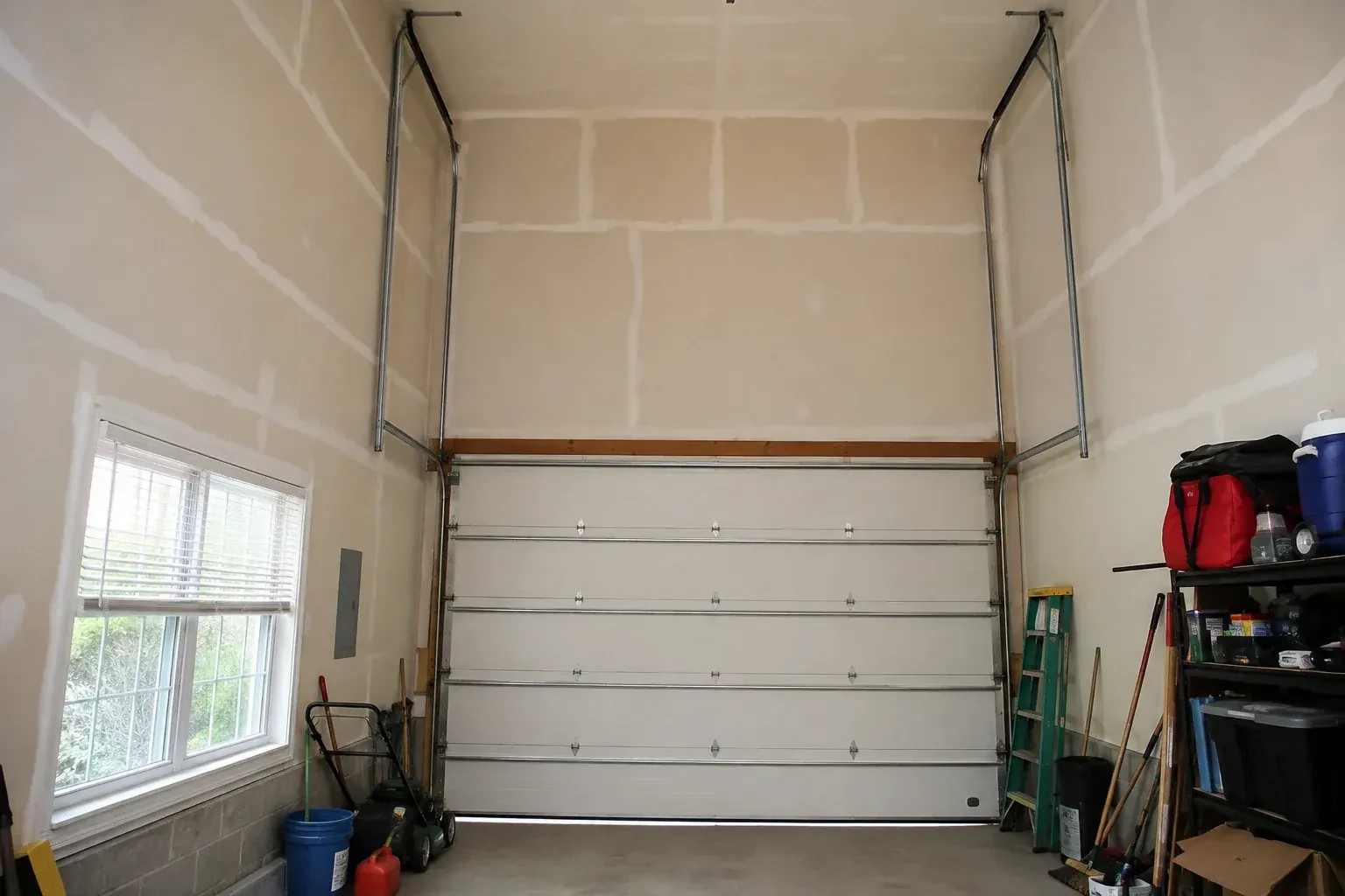 Tall garage interior with a sectional door and tracks extending into overhead space. — High-Lift Garage Door Conversion, Markham